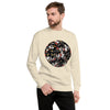 A man wearing a cream-colored crewneck sweatshirt with a circular graphic on the chest of tattoo style panther heads paired with black pants, set against a plain white background