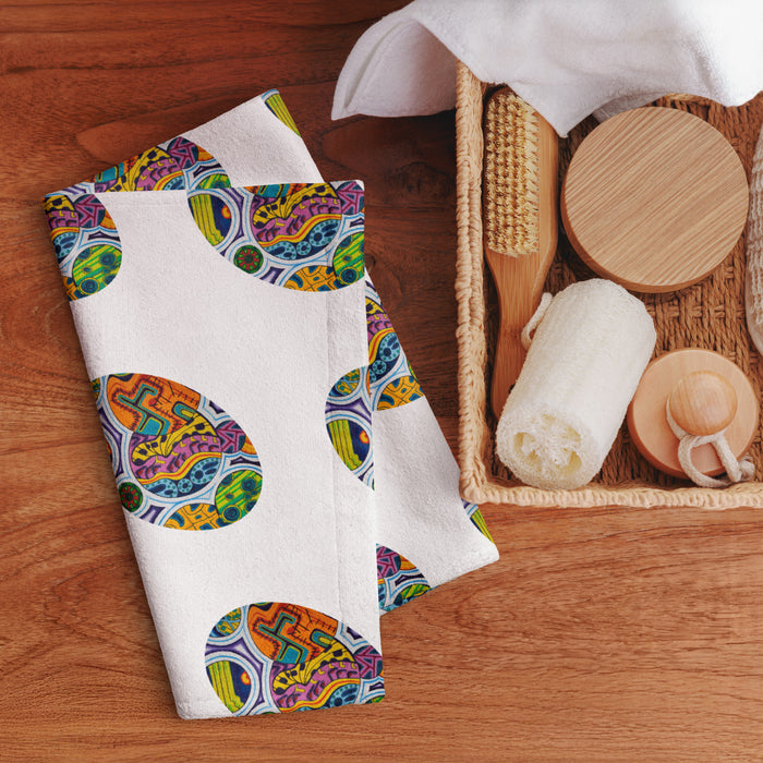 hand towel featuring repeating ovals of multicolored geometric shapes