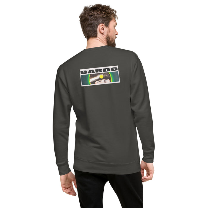 A man wearing a dark gray long-sleeve crewneck sweatshirt, viewed from the back. The sweatshirt features a graphic print on the upper back with the 'BARDO KID' logo n white block letters above a colorful rectangular illustration. of a young boys face