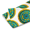 repeating circular floral artwork in turquoises, browns, and yellows on a hand towel