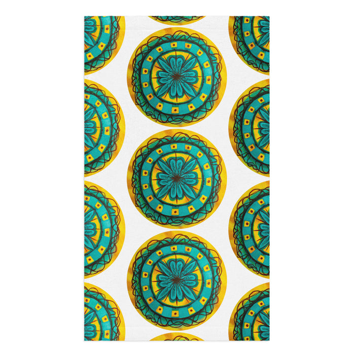 repeating circular floral artwork in turquoises, browns, and yellows on a hand towel