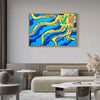 a rectangular oil painting depicting an undulating octopus type organism in bright yellow, orange, and teal in front of an electric blue background hanging above a tan couch