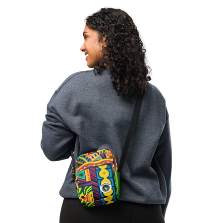woman wearing a cross body bag with an all over multicolored psychedelic artwork print