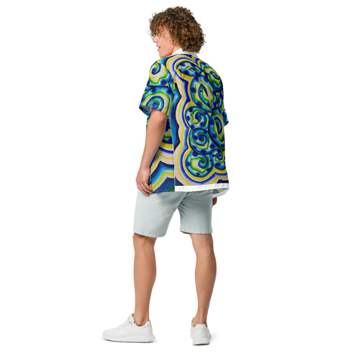 side view of a man wearing a short sleeve button up shirt with an all over design of blue, green, and yellow spirals