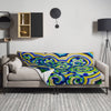 Colorful spiraling aquatic patterned blanket draped over a gray sofa in a modern living room.