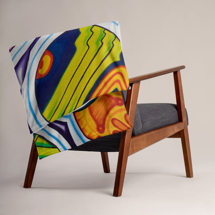 Colorful, psychedelic, abstract patterned blanket on a gray sofa in a modern living room.