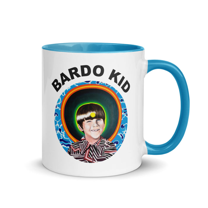 white mug with blue handle and inside with bardo kid logo of young boy in front of a psychedelic background on side
