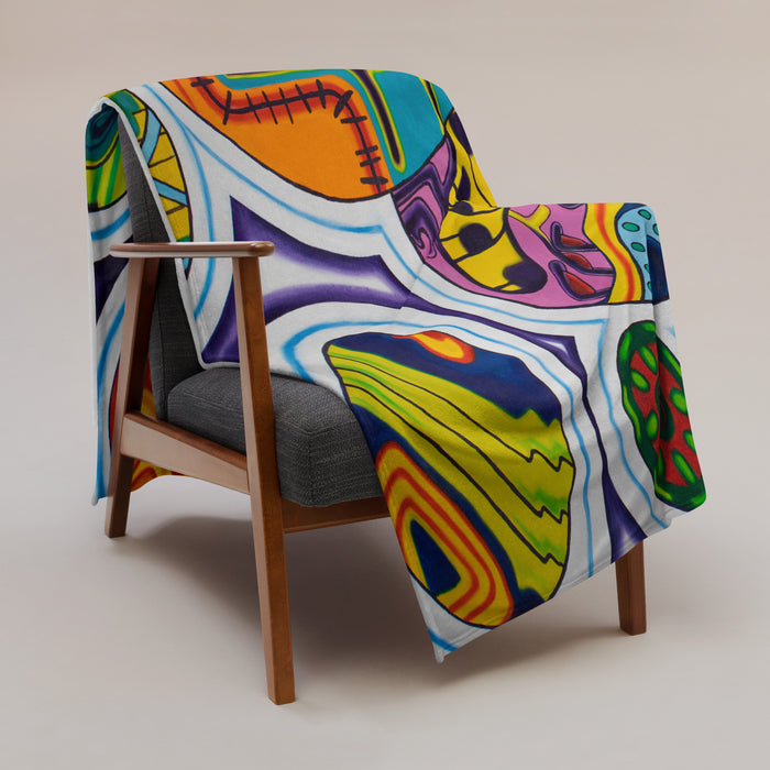 Colorful, psychedelic, abstract patterned blanket on a gray sofa in a modern living room.
