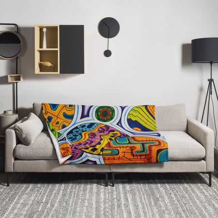 Colorful, psychedelic, abstract patterned blanket on a gray sofa in a modern living room.
