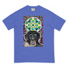 light blue t-shirt with a young chimpanzees face in front of a turquoise, green, and yellow psychedelic mandala with a background illustrated by pulsating geometric red and purple forms