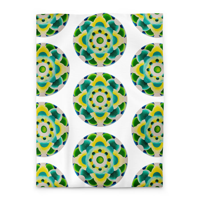 white duvet with an abstract circular repeating pattern made of circles in turquoise, green, and yellow.