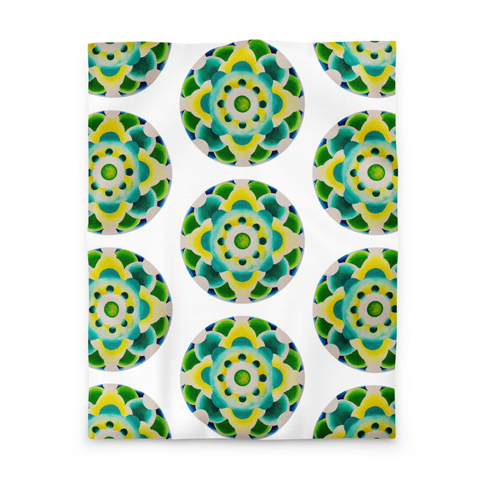 white duvet with an abstract circular repeating pattern made of circles in turquoise, green, and yellow.