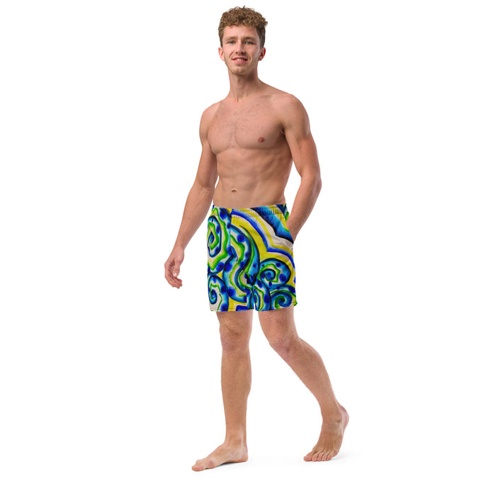 young man wearing shorts with an all over print of watercolor circular art in greens and blues