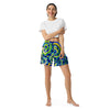 woman wearing athletic shorts with swirling circular abstract patterns of aquas, blues, greens, and yellows