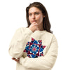 woman wearing a a beige long sleeve t-shirt featuring original watercolor art of a mandala made up of magenta, turquoise, and maroon circular forms.