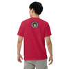  man wearing red t-shirt with original art of a deity with a pinecone head, octopus tentacles, elk antlers, and a Tibetan circular glow around it in front of a lightning storm and bardo kid logo on back