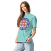  girl wearing a aqua t- shirt with the Bardo Kid logo on the upper middle back and a psychedelic flower design in reds, blues, and oranges on front.