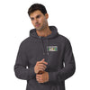 A man wearing a dark heather gray hoodie with a l graphic print on the chest of the bardo kid logo a young boys face