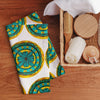 repeating circular floral artwork in turquoises, browns, and yellows on a hand towel