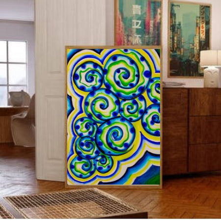 A framed abstract art print featuring vibrant blue, green, and yellow swirling patterns, displayed in a modern living room setting next to a wooden cabinet.