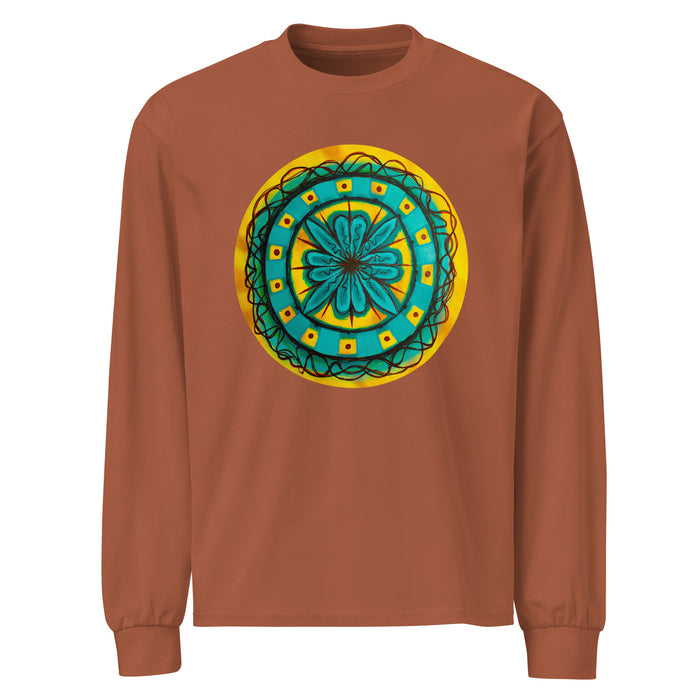 a light brown long sleeve t-shirt with circular original art of a turquoise geometric flower surrounded with squiggly lines on a mustard yellow backround.