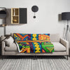 Colorful abstract, psychedelic patterned blanket with vibrant colors draped over a living room couch 