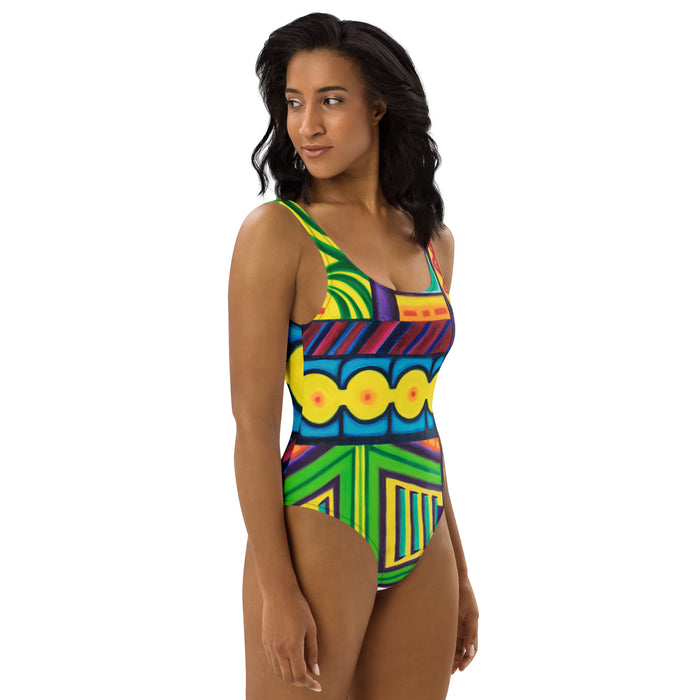  woman wearing an original art one piece womens swimsuit with a multicolored all over psychedelic print of geometric shapes