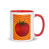 white and red coffee cup with a tomato with radiating red and yellow striped around it.
